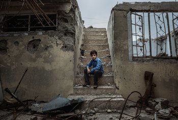Mohammed, 10, sits on the staircase of the former house he used to hide with his family in Mosul.