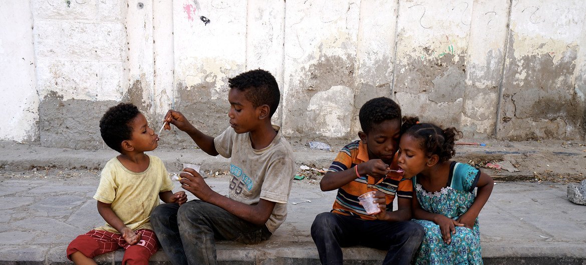 أطفال يطعمون بعضهم بعضا في أحد شوارع عدن
