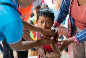 2018年老挝溃坝事故发生后，一名受到水灾影响的男孩正在接种疫苗。
