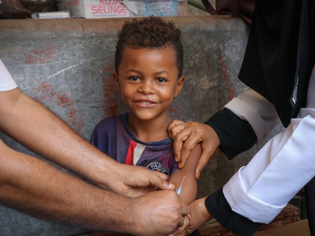 Mtoto akitabasamu wakati anapokea chanjo za surua na Rubella wakati kampeni ya chanjo iliyowezeshwa na UNICEF kwenye jimbo la Aden nchini Yemen 2019