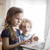 Deux enfants de six et quatre ans devant un ordinateur portable à Podgorica, la capitale du Montenegro