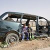 طفلان من النازحين داخليا يجلسان في إحدى السيارات المدمرة في مستوطنة قريونس للنازحين في بنغازي. ويعيش في هذه المستوطنة أكثر من  200 أسرة ، جميعهم تقريباً نزحوا من تاورغاء في عام 2011.