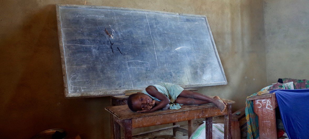 A child rests on a table in the classroom where her family is sleeping at a school used as a collective centre for internally displaced people in Oicha, Beni territory, North Kivu.