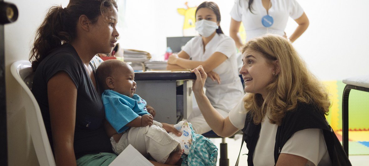 On 23 April 2019 in Cucuta in Colombia, (right) UNICEF Director of the Division of Communication Paloma Escudero speaks with a woman and a child at the UNICEF-supported health centre.