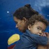 A Cucuta, en Colombie, en avril 2019, une mère et son enfant en provenance du Venezuela se reposent avant de poursuivre leur périple vers Cali en Colombie.e