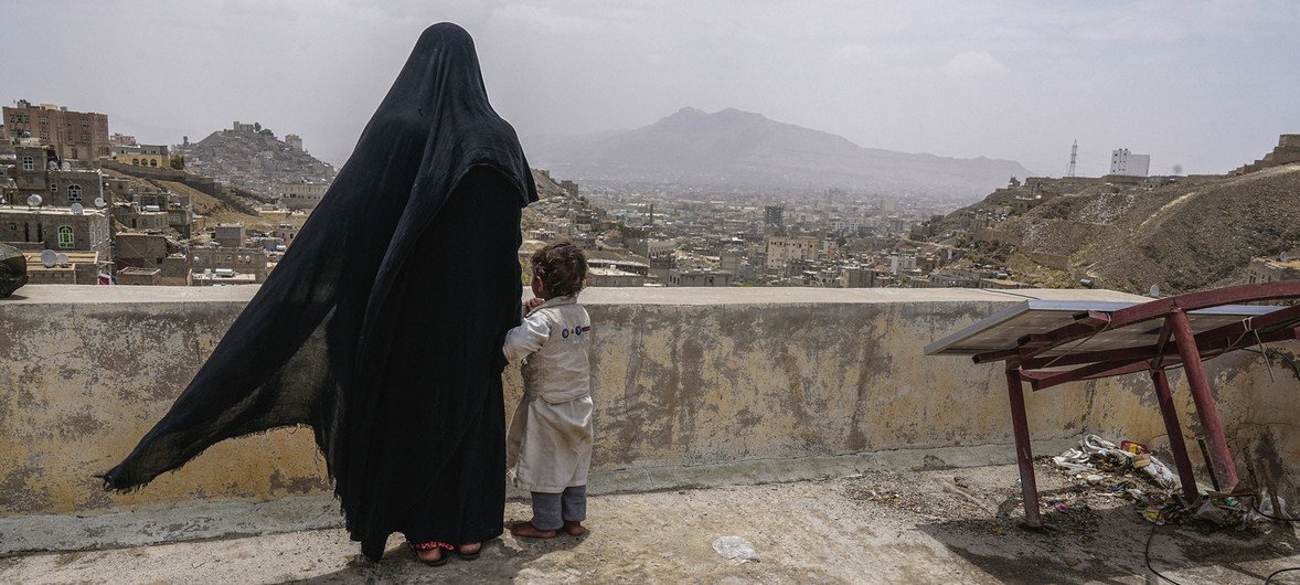 哈桑和女儿法奇娅站在一座废弃房屋的屋顶上眺望也门首都萨那。