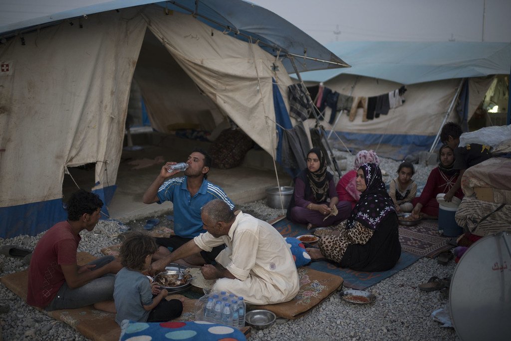 أسرة عراقية نازحة تتناول وجبة الإفطار في شهر رمضان، في مخيم للمشردين داخليا في كردستان العراق.