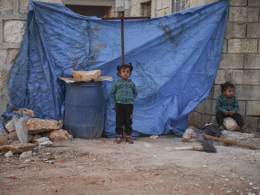 Des enfants et leurs familles vivant dans un camp de fortune difficile d'accès dans la région d'Alep, en Syrie.