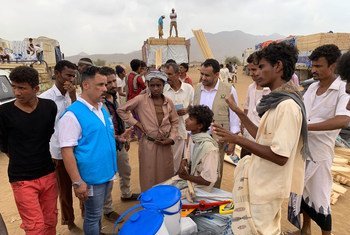 A UNHCR staff member talks to displaced children and others in Yemen's Hajjah Governorate. (21 March 2019)