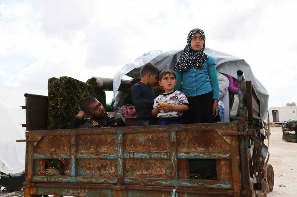 أسرة سورية تفر من منطقة النزاع على ظهر شاحنة في منظقة قريبة من كفر لوزين في مايو 2019.