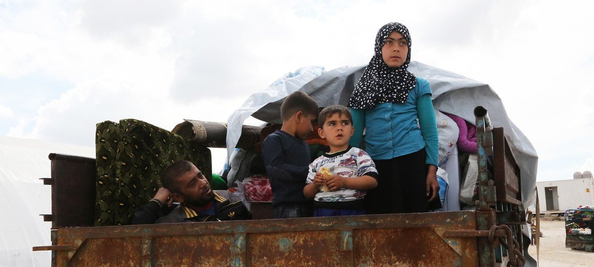A family in Syria flees a conflict zone in the back of a truck near Kafr Lusein in May 2019.