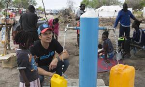  Orlando Bloom ajuda uma criança a encher um galão cheio de água da Unicef no local de reassentamento de Mendruzi para pessoas deslocadas pelos recentes ciclones.