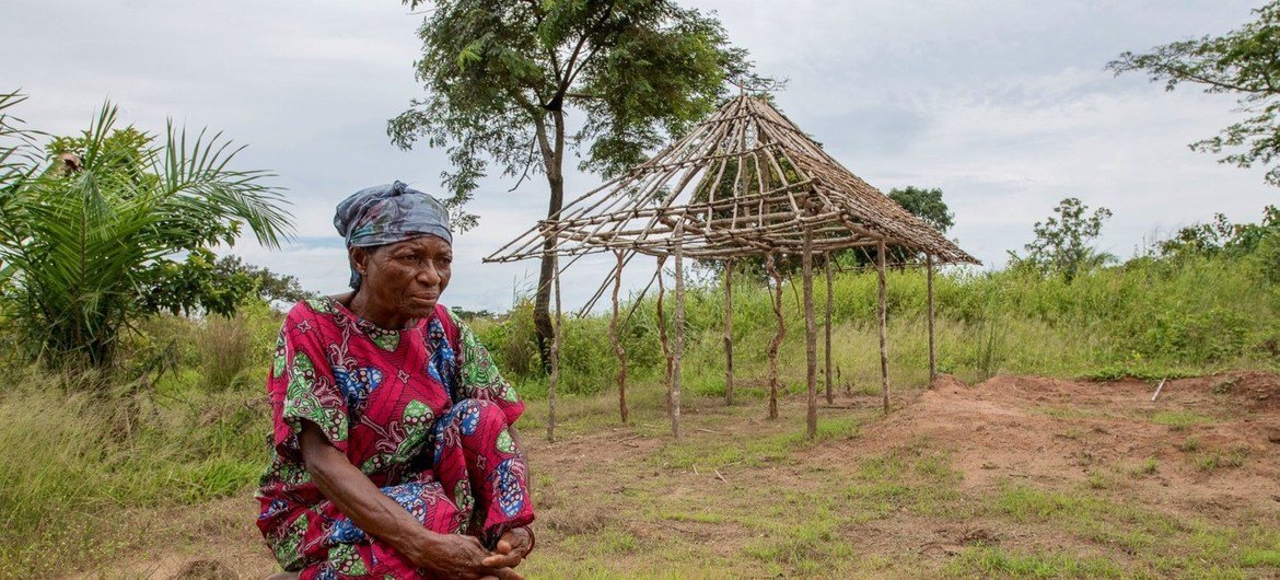 Rose examine les restes de sa maison et de son jardin incendiés qu'elle a dû abandonner après l'attaque de son village de Kajiba, dans la région du Kasaï, en RDC.