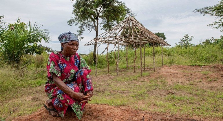 Rose examine les restes de sa maison et de son jardin incendiés qu'elle a dû abandonner après l'attaque de son village de Kajiba, dans la région du Kasaï, en RDC.