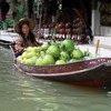 A saleswoman sells Asian grapefruits on a floating market.