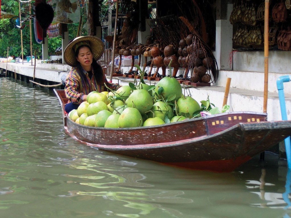 一位妇女在水上市场出售柚子。