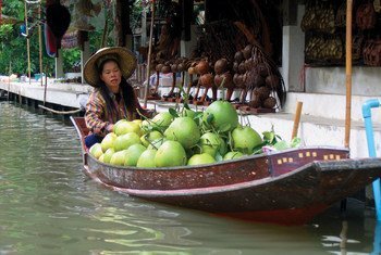 A saleswoman sells Asian grapefruits on a floating market.