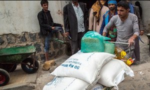 A beneficiary pushes a wheelbarrow containing food rations at a food distribution point in Sana’a. (3 February 2019)