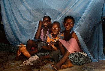 Mawunya Agbeko (13), Lord Mensah (4) and Abigail Xorghli (9) with the long-lasting insecticide-treated net (LLIN) they share at their home in the fishing village of Abakam in the Central Region of Ghana on 5 October 2012. LLINs have been shown to be effec
