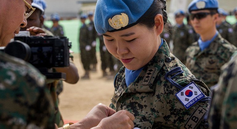 A female peacekeeper from South Korea receives a UN medal at a medal parade ceremony.