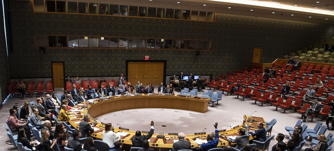 Membros do Conselho de Segurança da ONU presentes no plenário levantam as mãos durante a votação de um relatório referente ao Sudão e ao Sudão do Sul.