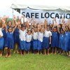 Children in a Samoan village gathered at a safe location during a disaster drill. 
