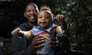 Bongani Ngqame在南非开普敦他在卫生局的办公室附近的公园里与他8个月大的儿子Khuma一起照相。