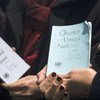 Participantes de um evento na ONU seguram cópias da Carta das Nações Unidas