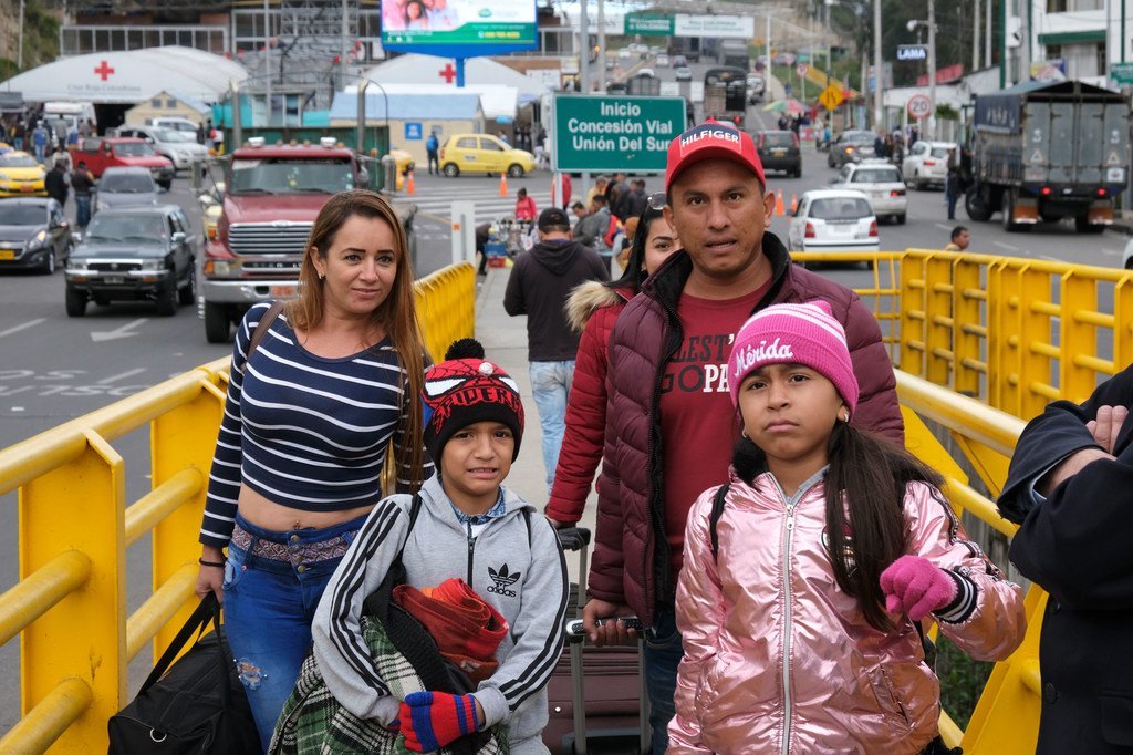 Une famille du Venezuela confrontée à la crise dans leur pays traverse un pont à la frontière entre l'Equateur et la Colombie en juin 2019.