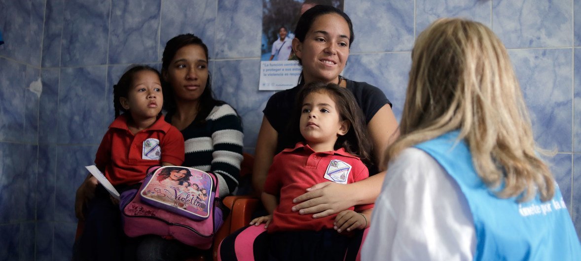 Dans une école de la banlieue de Caracas, au Venezuela, une représentante de l'UNICEF s'entretient avec une mère qui a amené sa petite fille pour un dépistage nutritionnel. (3 juin 2019)