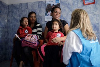 Dans une école de la banlieue de Caracas, au Venezuela, une représentante de l'UNICEF s'entretient avec une mère qui a amené sa petite fille pour un dépistage nutritionnel. (3 juin 2019)