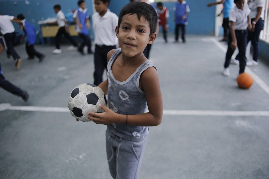 Un enfant joue au football sur le toit de l'école El Carmen, à Barrio Union, dans la banlieue de Caracas, au Venezuela.