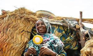 Hauwa's GOGLA lamp helps her cook and carry out other chores around her home, and it helps her children study.