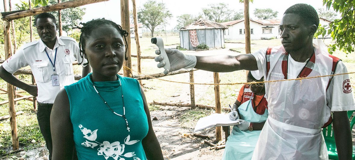 Un volontaire de la Croix-Rouge en Ouganda prend la température d'une femme en provenance de République démocratique du Congo pour détecter les symptômes d'Ebola (février 2019).