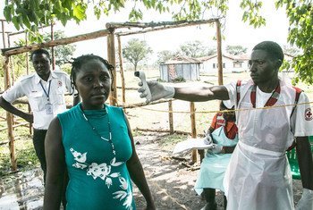 Un volontaire de la Croix-Rouge en Ouganda prend la température d'une femme en provenance de République démocratique du Congo pour détecter les symptômes d'Ebola (février 2019).