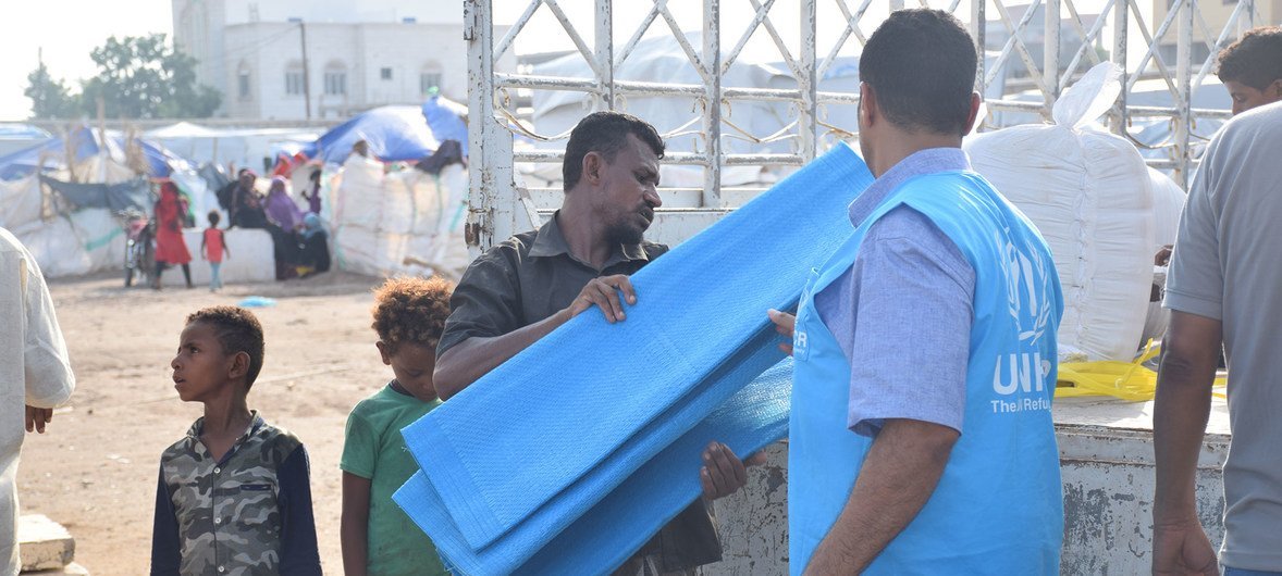 Wafanyakazi wa UNHCR wakisambaza misaada ya kibinadamu kwa wakimbizi wa ndani huko Aden nchini Yemen baada ya mvua kubwa kunyesha mjini humo tarehe 10 Juni 2019