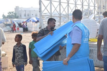 UNHCR staff distribute aid to internally displaced people in Aden after heavy rains hit the city. (10 June 2019)