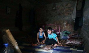 Having fled hostilities in Syria's Idlib, two boys have a meal in their temporary shelter, near the Turkish border.  (June 2019)