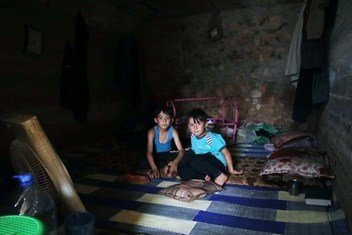 Deux garçons ayant fui les hostilités à Idlib, en Syrie, prennent leur repas dans un abri temporaire près de la frontière turque. (juin 2019)