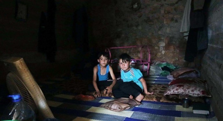 Dos niños que huyeron de la violencia en Idlib, Siria, reciben comida en un campamento temporal de desplazados cerca de la frontera con Turquía.