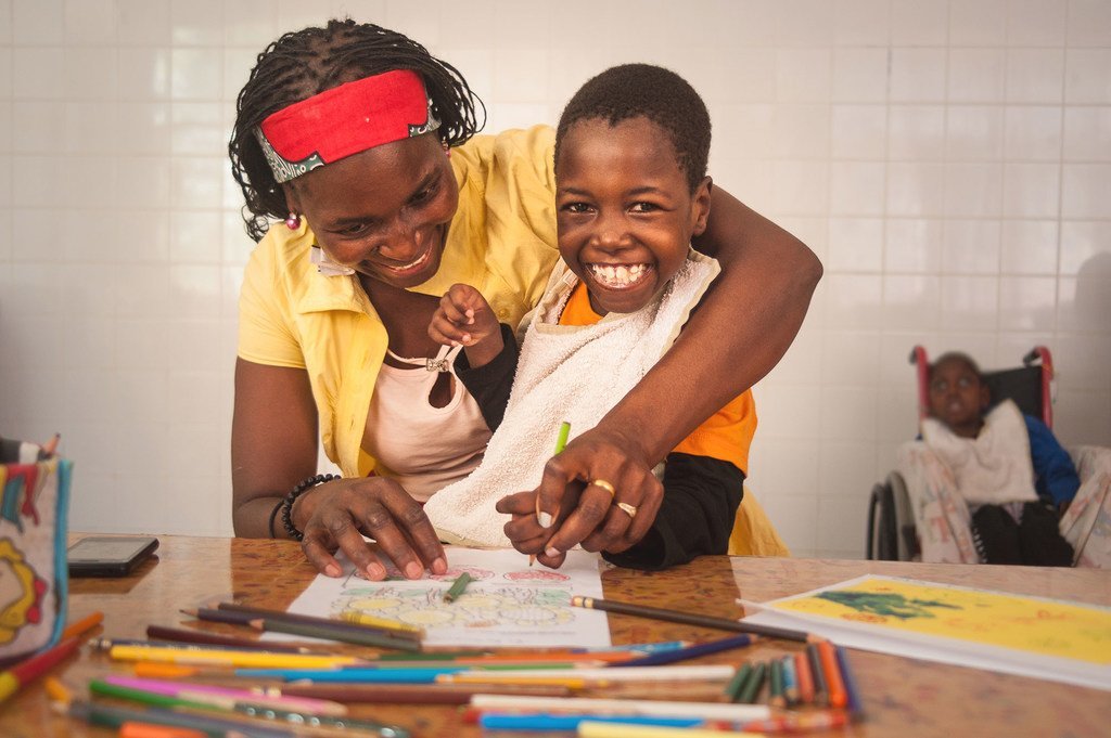 Filomena, 8ans, née avec une tétraplégie spasmodique et une épilepsie, et sa mère colorient des dessins au centre de réadaptation psychosociale de Maputo, au Mozambique. (8 octobre 2018)