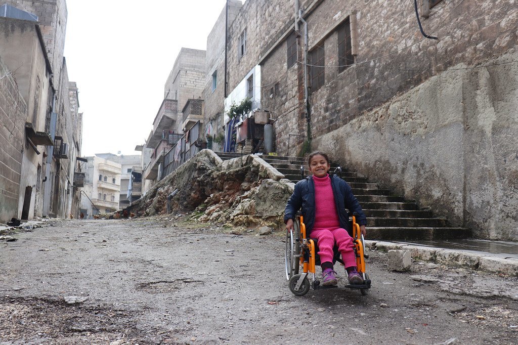Hanaa, huit ans, paralysée par l'explosion d'une bombe et ayant perdu l'usage de ses jambes, est assise dans son fauteuil roulant près de sa maison à Alep-Est, en Syrie (28 février 2018).
