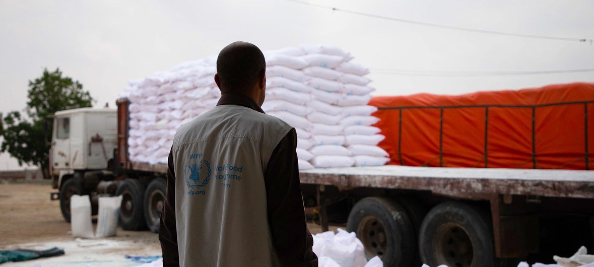 A World Food Programme worker in Khudaish Camp in Yemen looks at a truck being primed to deliver aid in early June 2019.