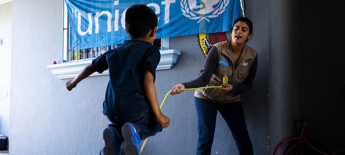 Un niño en un centro de Tijuana en México juega con una trabajadora de UNICEF.