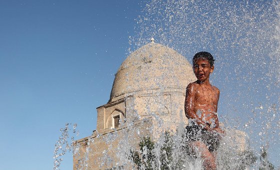 Menino de 11 anos no Uzbequistão refresca-se da onda de calor. OMS pediu que nas Américas os países estejam preparados para o fenômeno.