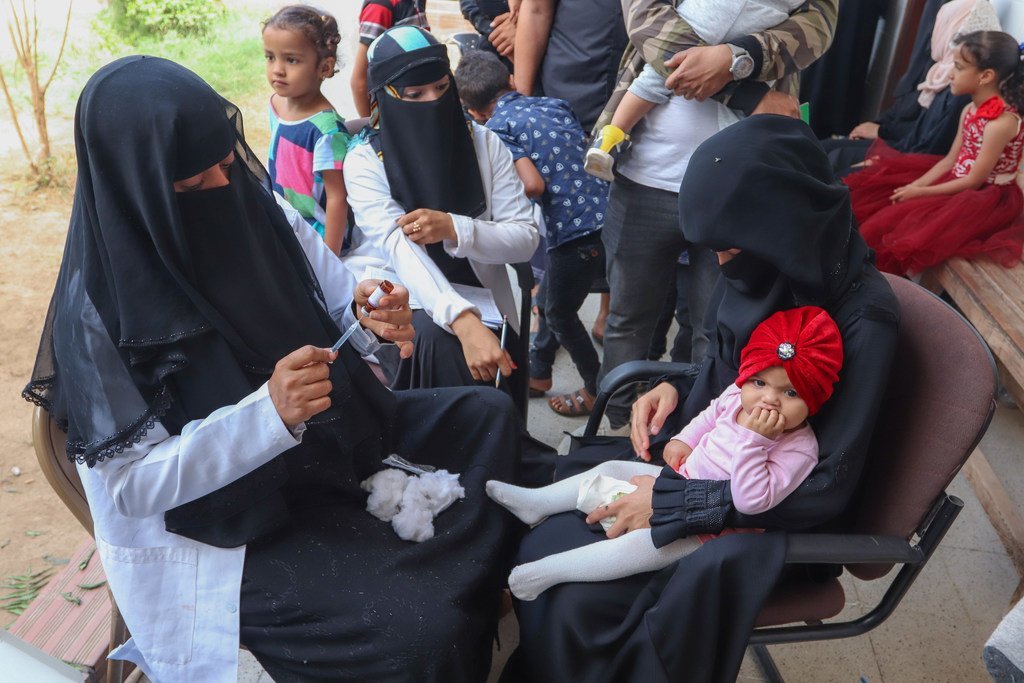 Une agent de santé d'Aden, au Yémen, remplit une seringue alors qu'elle se prépare à vacciner une jeune fille pendant une campagne de vaccination contre la rougeole et la rubéole soutenue par l'UNICEF en février 2019.