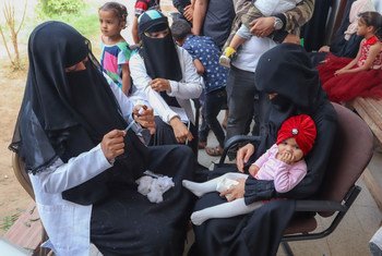 Une agent de santé d'Aden, au Yémen, remplit une seringue alors qu'elle se prépare à vacciner une jeune fille pendant une campagne de vaccination contre la rougeole et la rubéole soutenue par l'UNICEF en février 2019.