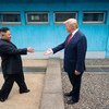 زعيما الولايات المتحدة (يمين) وكوريا الشمالية (يسار) يلتقيان في منطقة نزع السلاح الفاصلة بين الكوريتين. 30 يونيه/حزيران 2019.