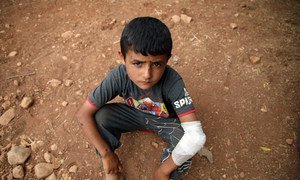 An injured boy rests on the ground of a makeshift camp in Syria's Aqrabat village, 45km north of Idlib City, near the Turkish border. (June 2019)