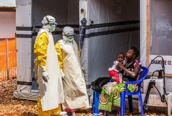 Des professionnels de santé rendent visite à une mère et sa fille en quarantaine dans le centre de traitement d'Ebola de Butembo, dans le Nord-Kivu, en République démocratique du Congo (mars 2019).